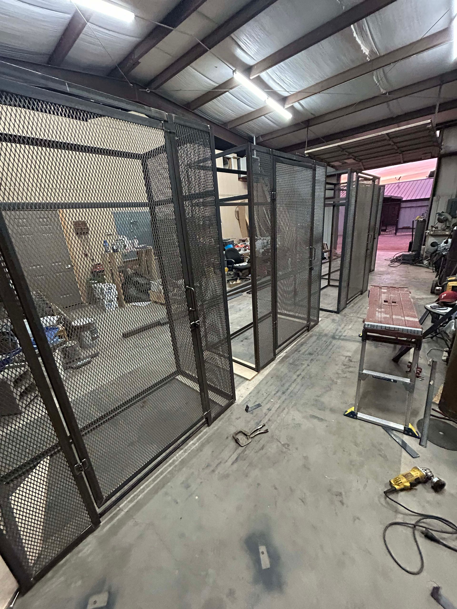 Metal mesh partitions in a workshop. Dark frames with a perforated pattern. Industrial setting with tools and equipment.