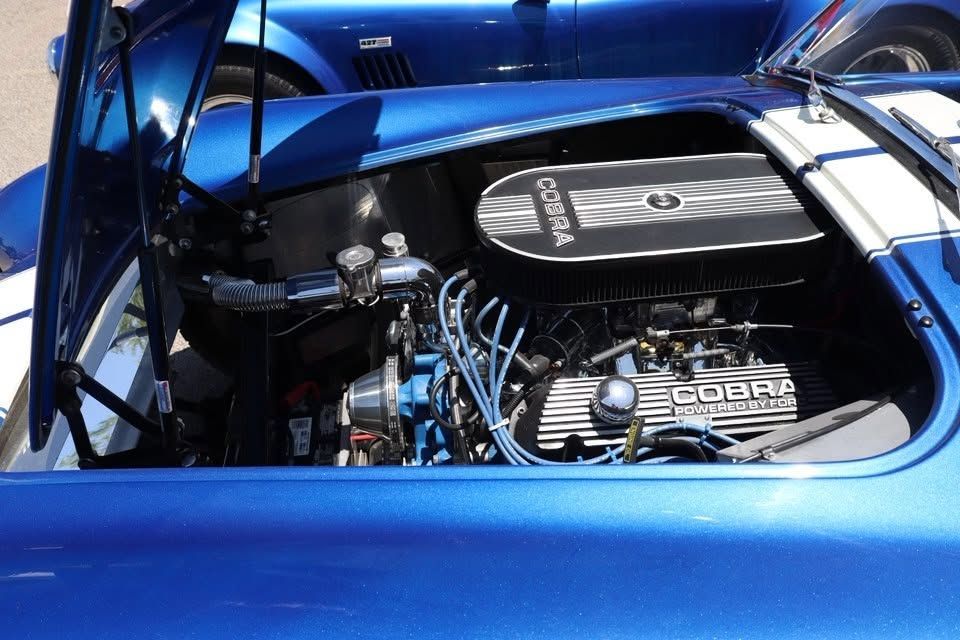 Blue sports car engine bay with chrome V8 and blue ignition wires, viewed under an open hood | Pro Veterans Automotive