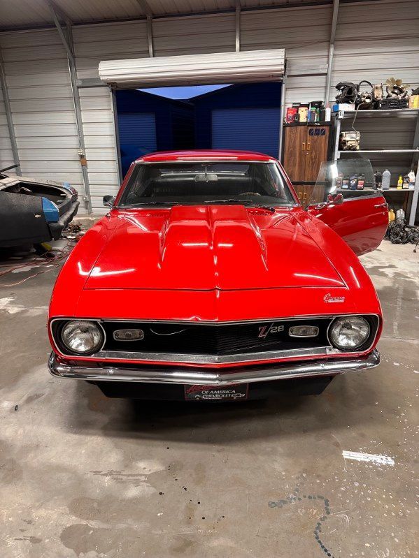 Red classic car in a garage, front view with the driver door open. | Pro Veterans Automotive