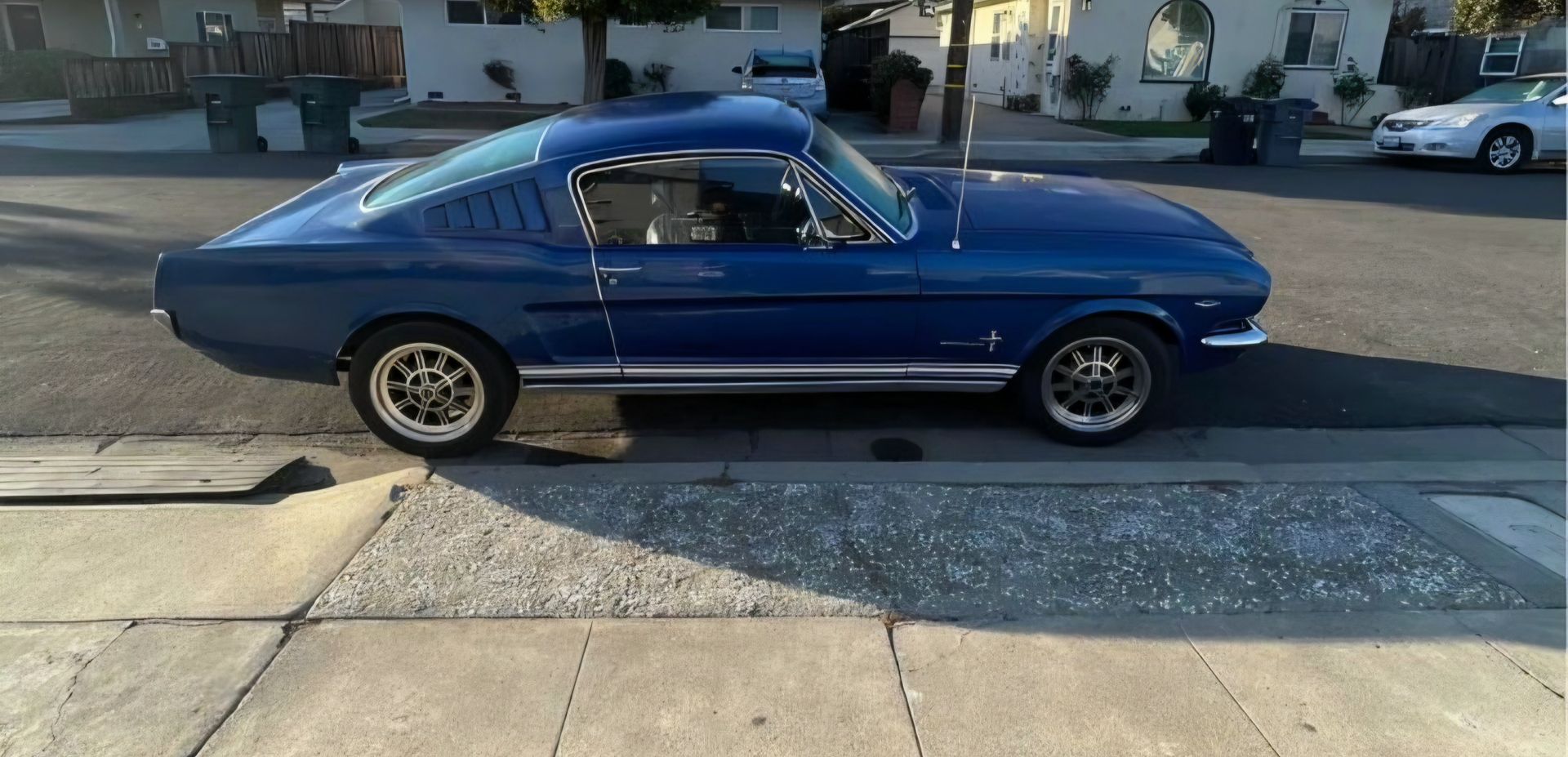 Blue classic coupe parked on a sunlit street beside a sidewalk | Pro Veterans Automotive