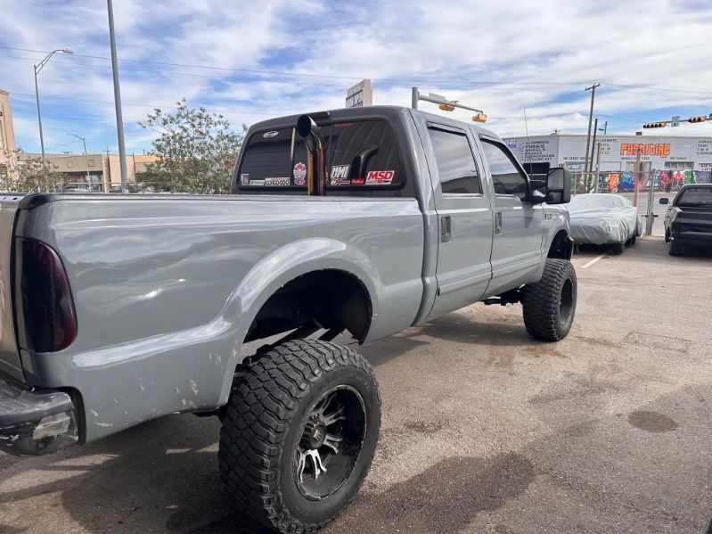 Lifted silver pickup truck with oversized tires parked outdoors on a street. | Pro Veterans Automotive