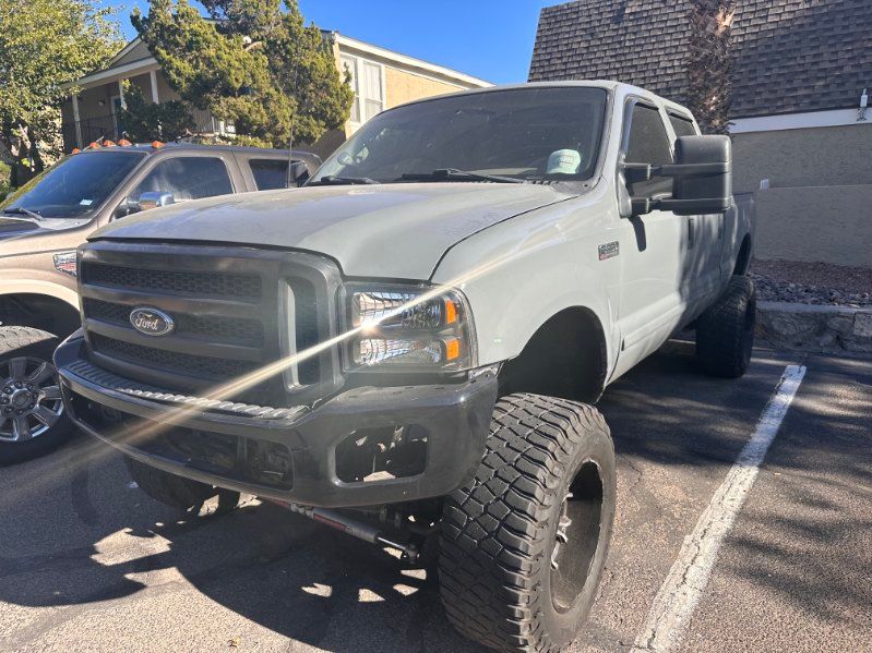 Lifted gray Ford pickup truck parked in a lot, front-left view, with sunlight glare on the hood. | Pro Veterans Automotive