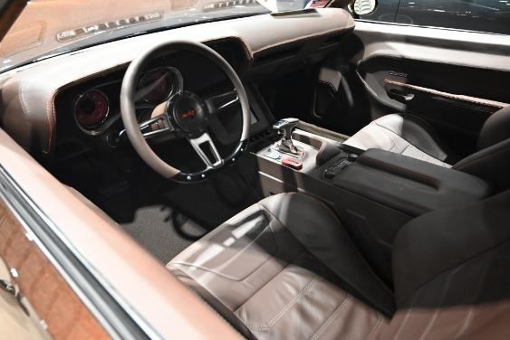 Vintage car interior with tan and black seats, steering wheel, and center console | Pro Veterans Automotive