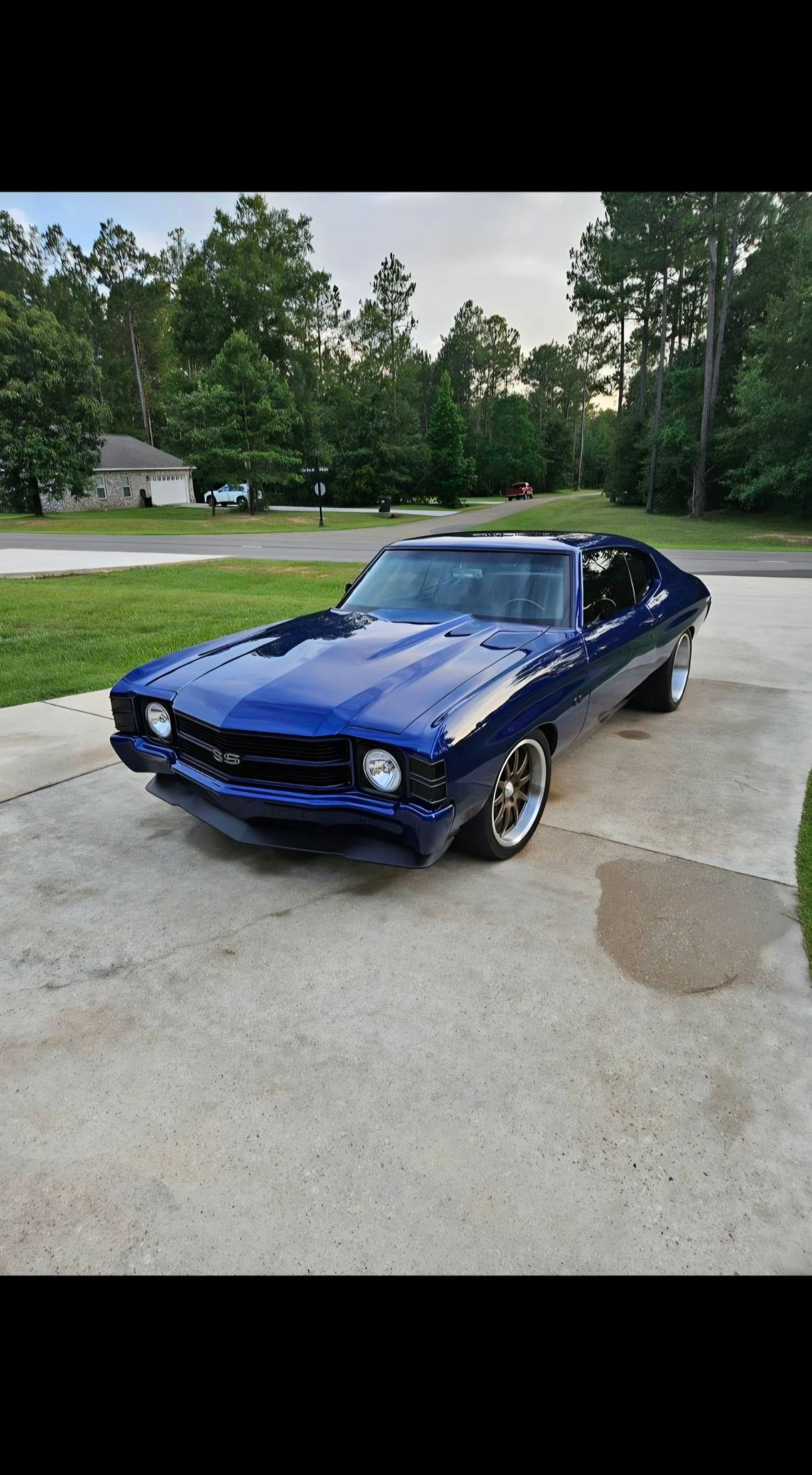 Blue classic car parked on a driveway with trees and a house in the background | Pro Veterans Automotive