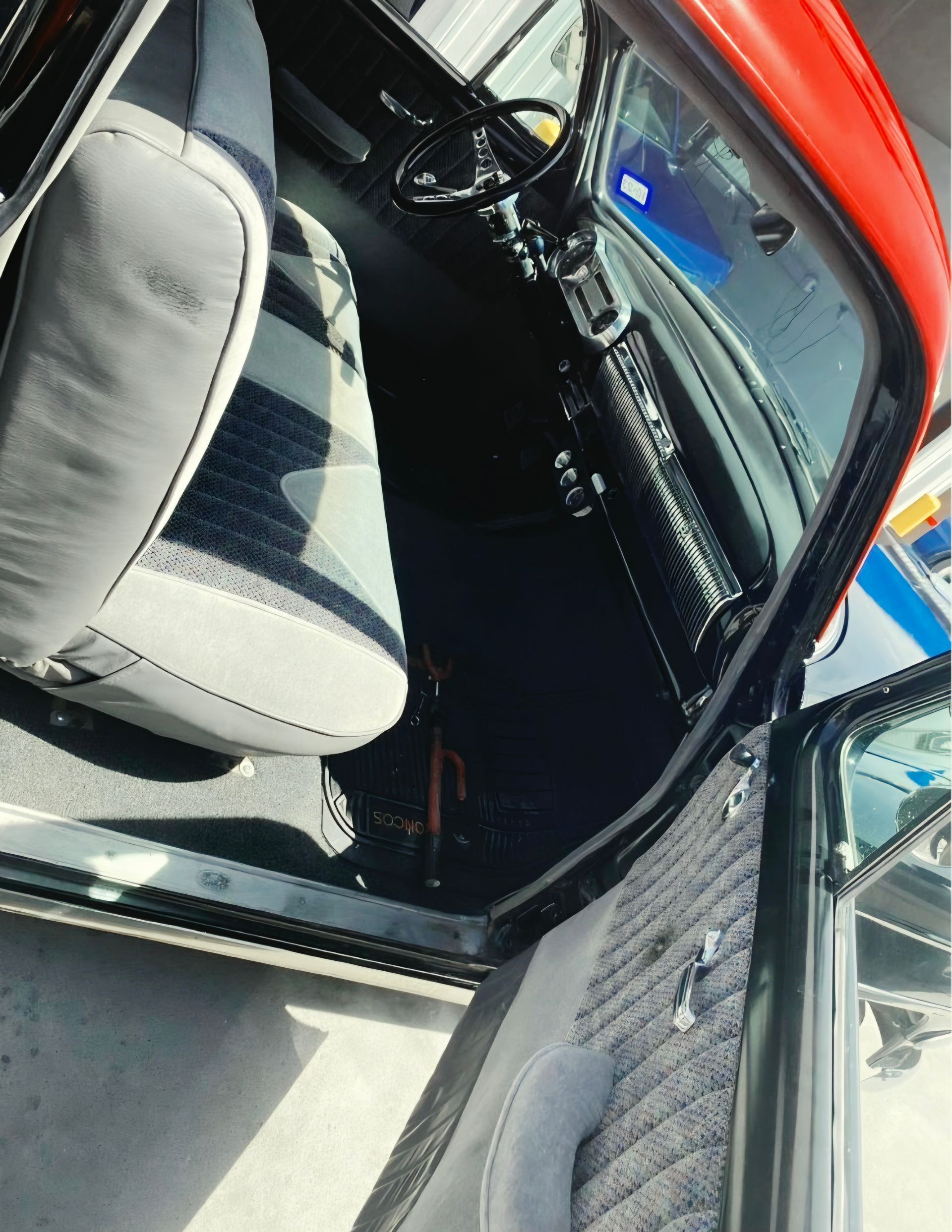 Car interior with gray seat, black dashboard, and red door frame viewed from the open side door | Pro Veterans Automotive