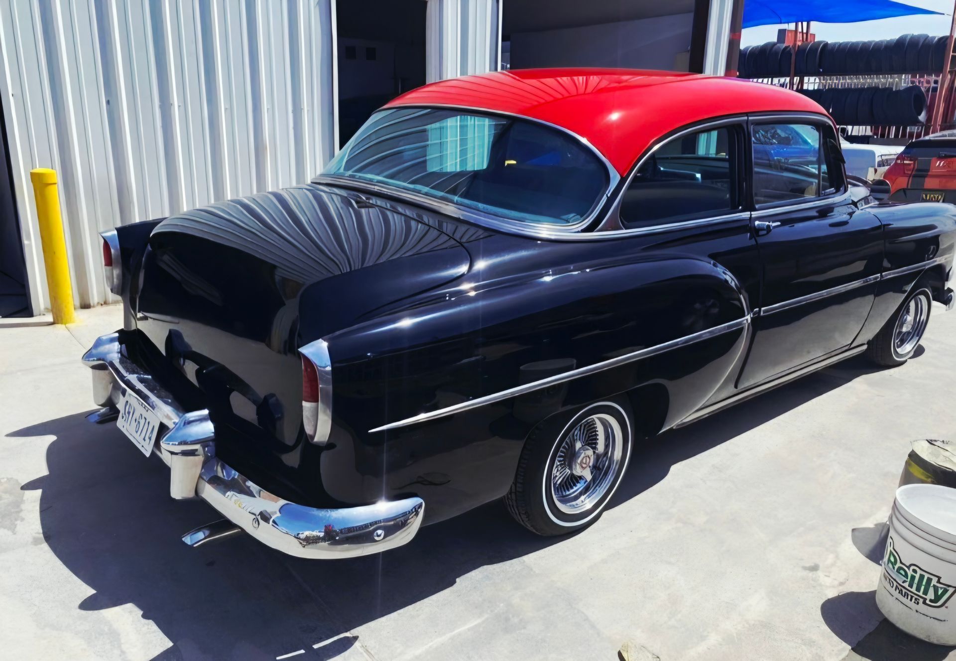 Classic black coupe with a red roof parked outside a building | Pro Veterans Automotive