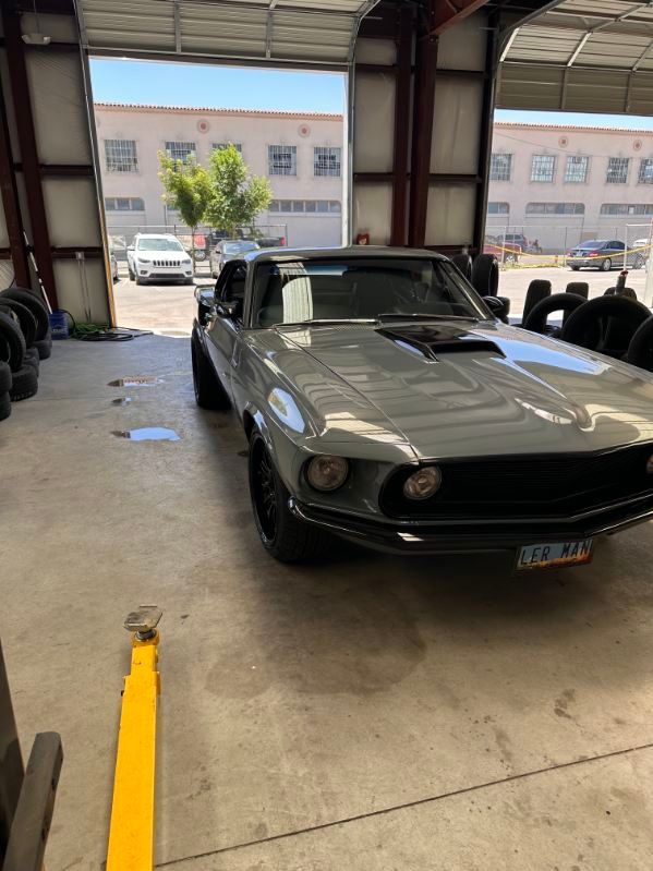 Classic black sports car in a garage, facing forward near the open entrance. | Pro Veterans Automotive