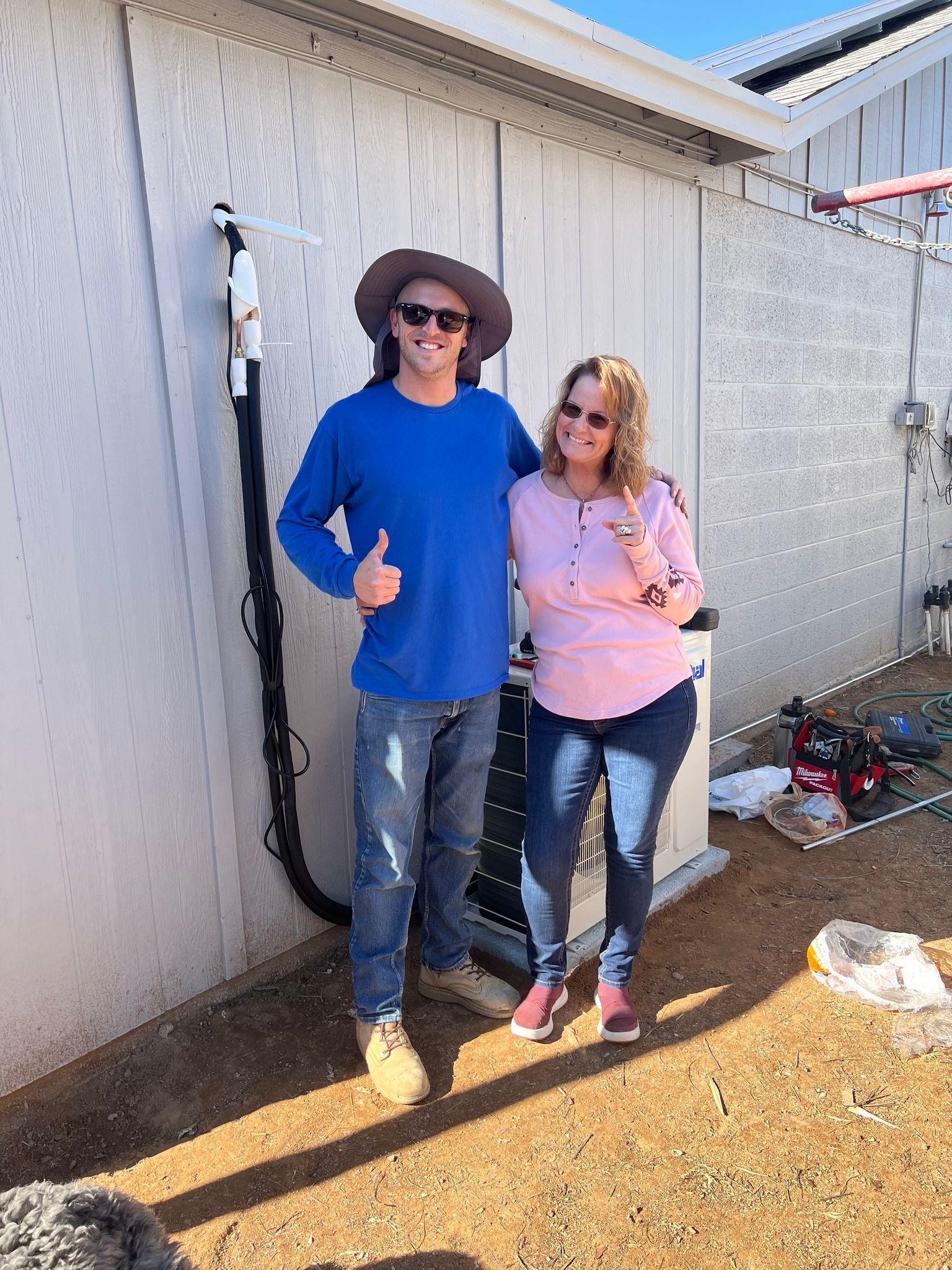A man and a woman are standing next to each other in front of a building.