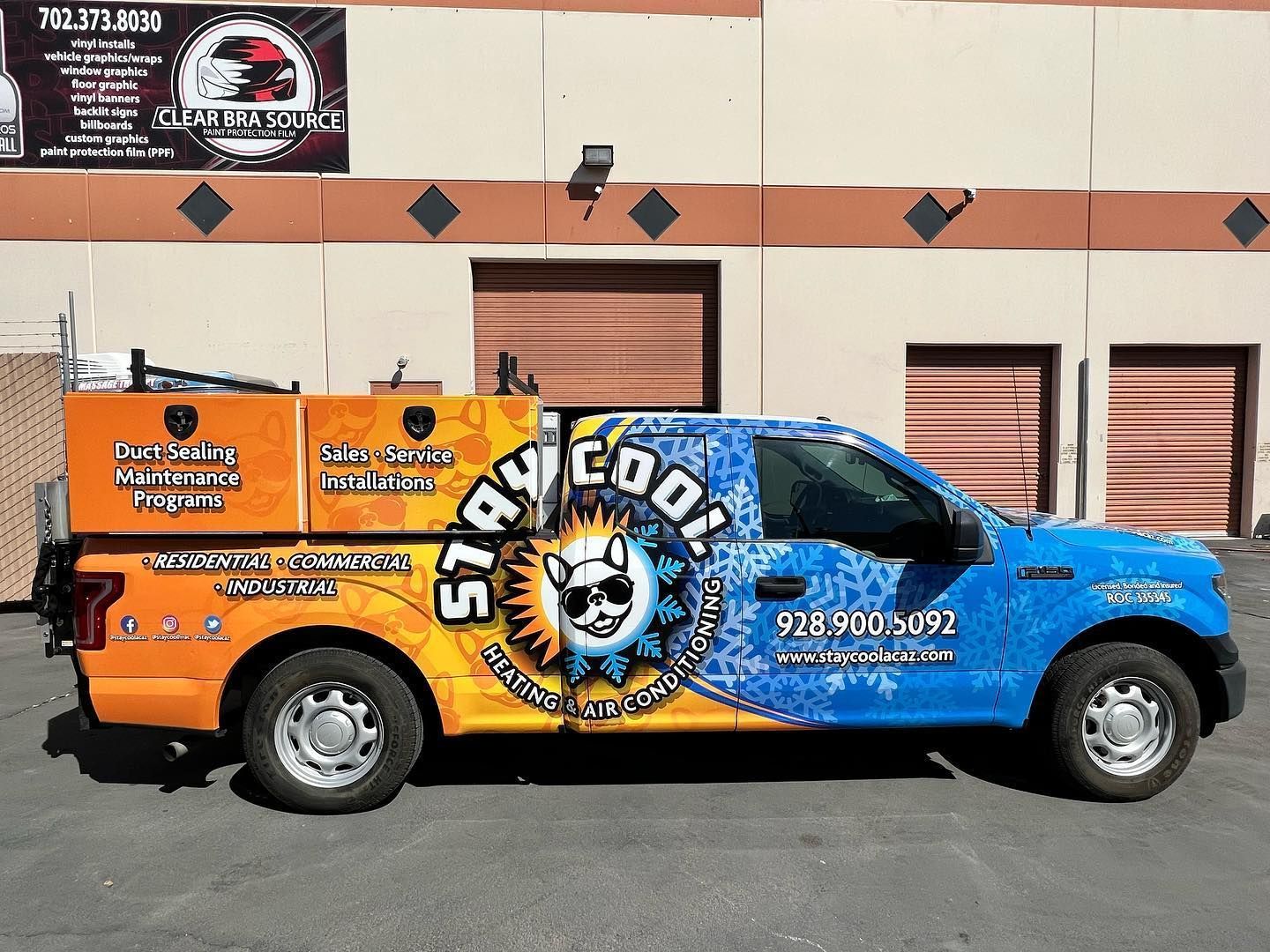 A truck with a wrap that says slam cool is parked in front of a building