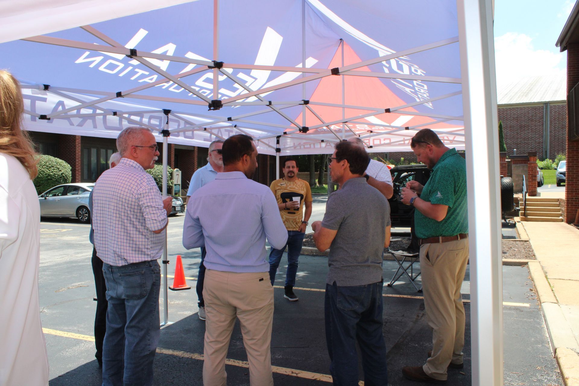 Group standing underneath Vestal Corporation pop up tent
