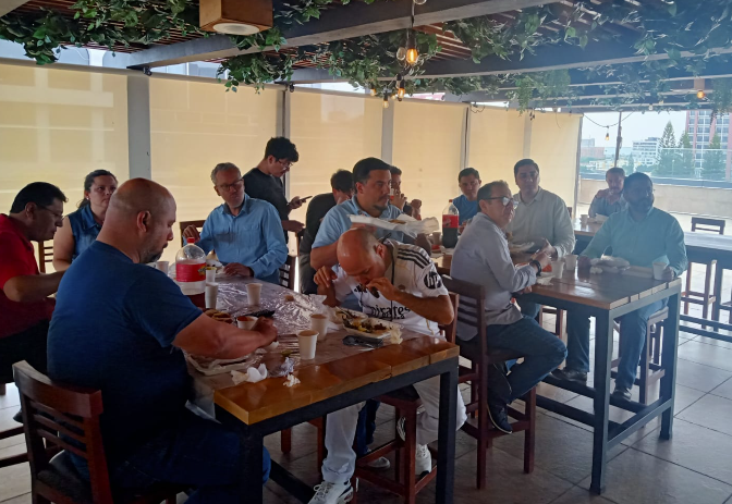 Large social gathering of people in a well decorated area eating food.