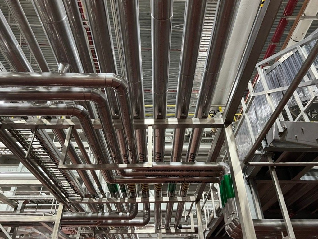 Industrial ceiling with dense metal pipes and ductwork in a factory or utility space