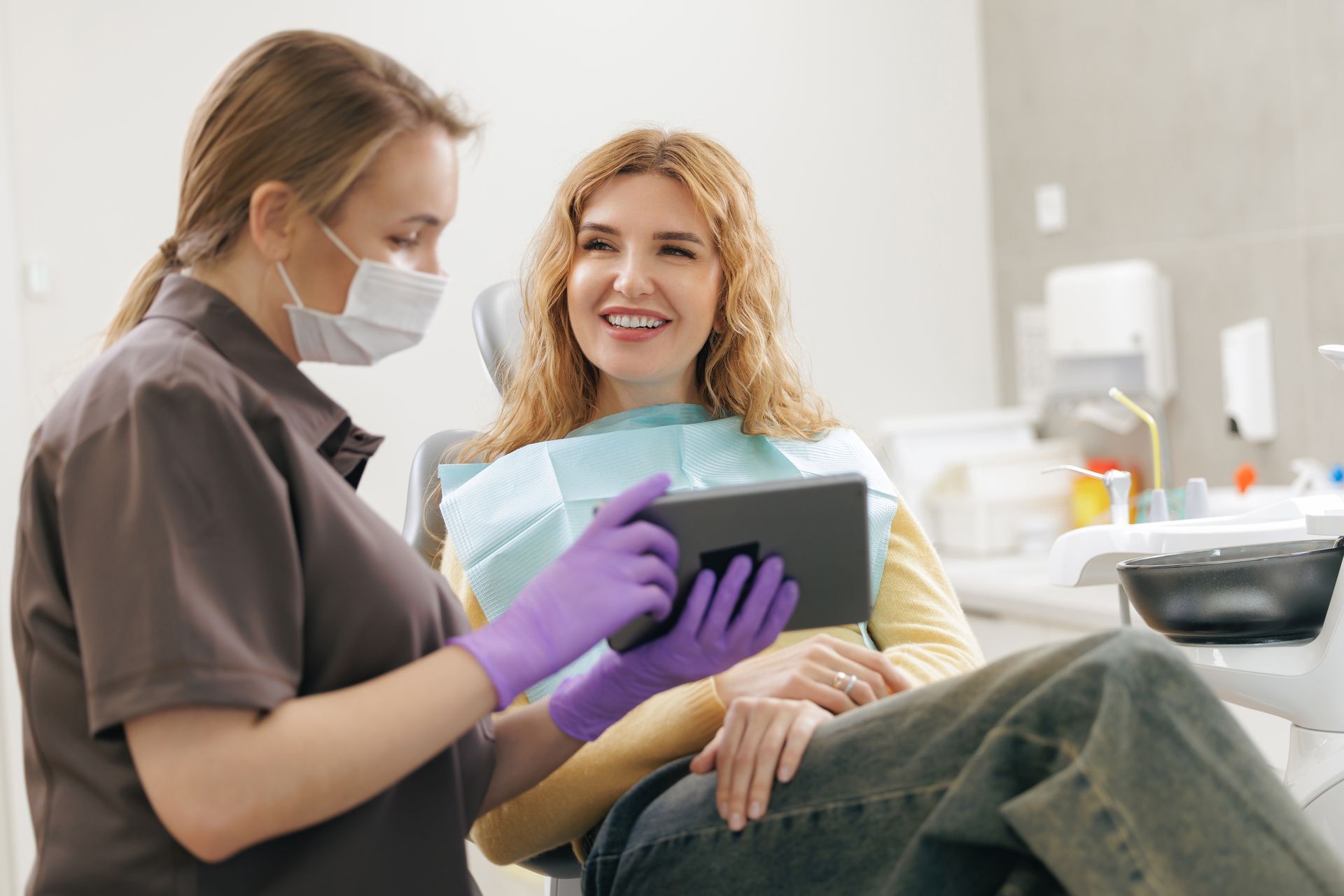 Dentist showing a tablet computer to a patient at a dental clinic.
