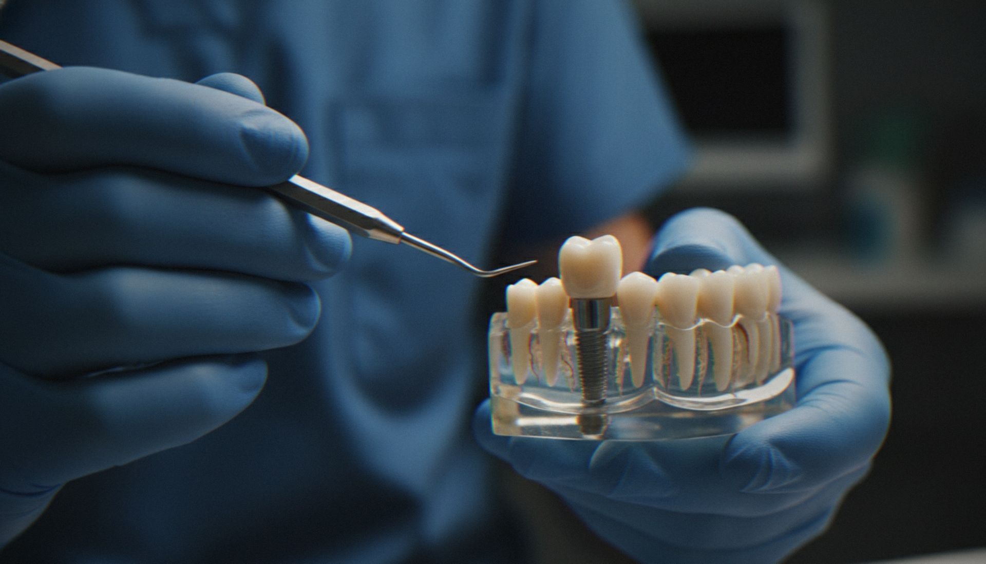 Gloved hands working on a dental mold with a dental tool in a clinic