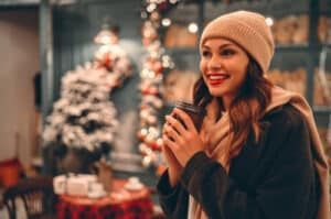 Woman smiling with composite veneers in winter holiday setting outside in Denver.