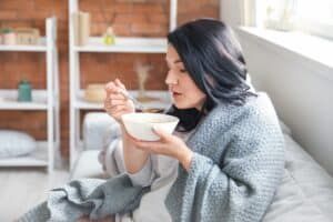 Woman eating soft food after getting a dental bridge in Denver