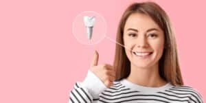 A woman is holding a tooth in her hand and giving a thumbs up.