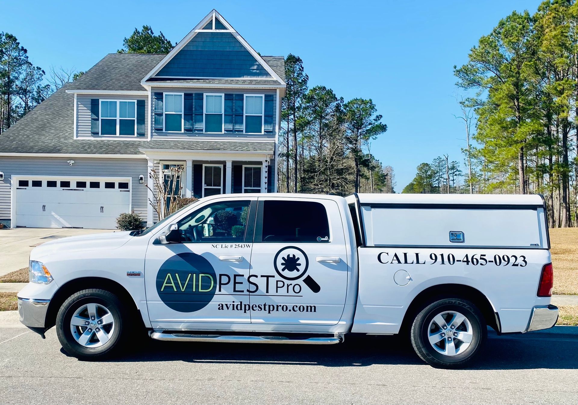 A white truck from avid pest pro is parked in front of a house.