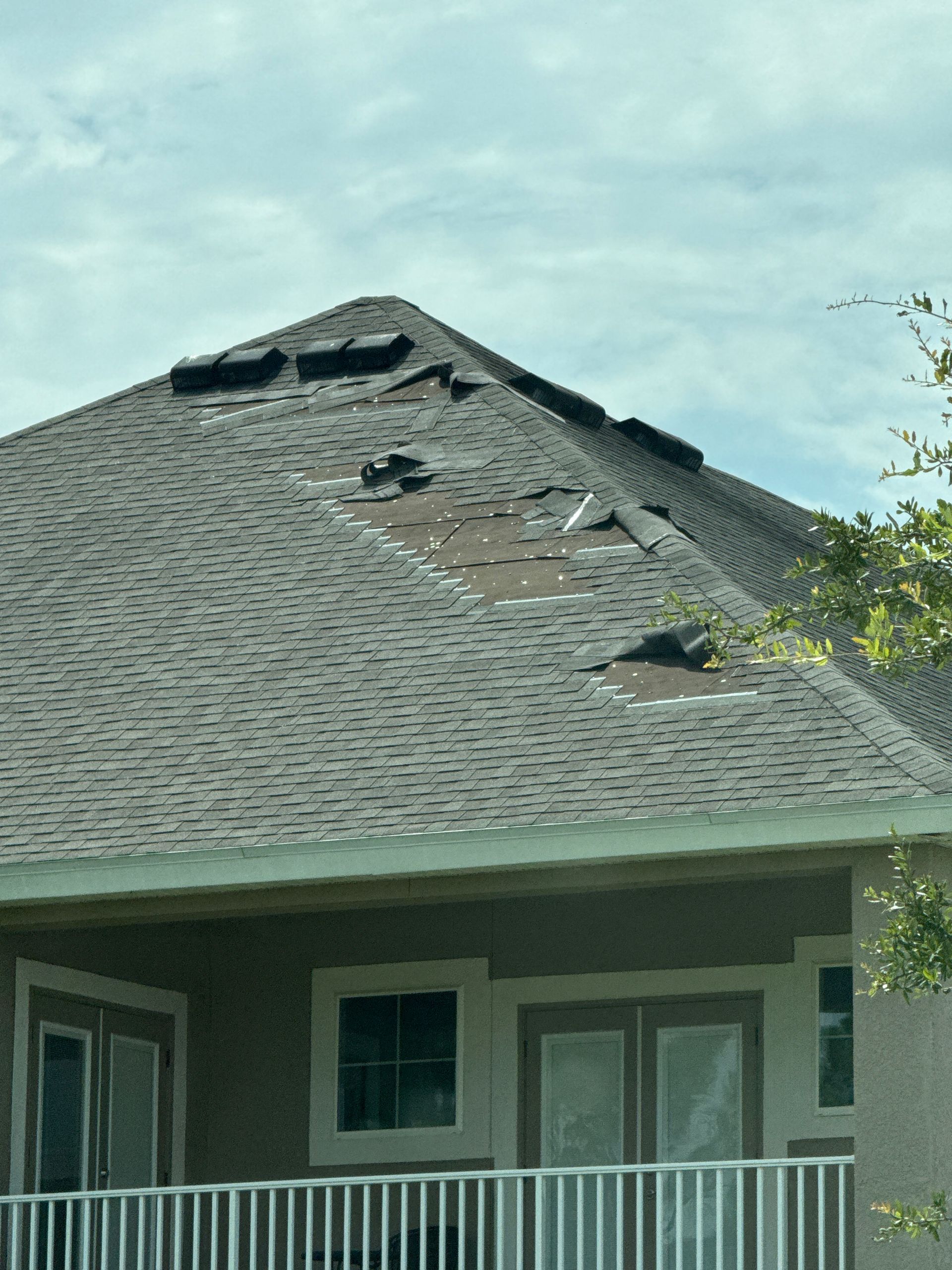 Roof repair near you: Red Truck Roofing project manager checking a Hillsborough County roof permit date on a tablet before quoting a repair