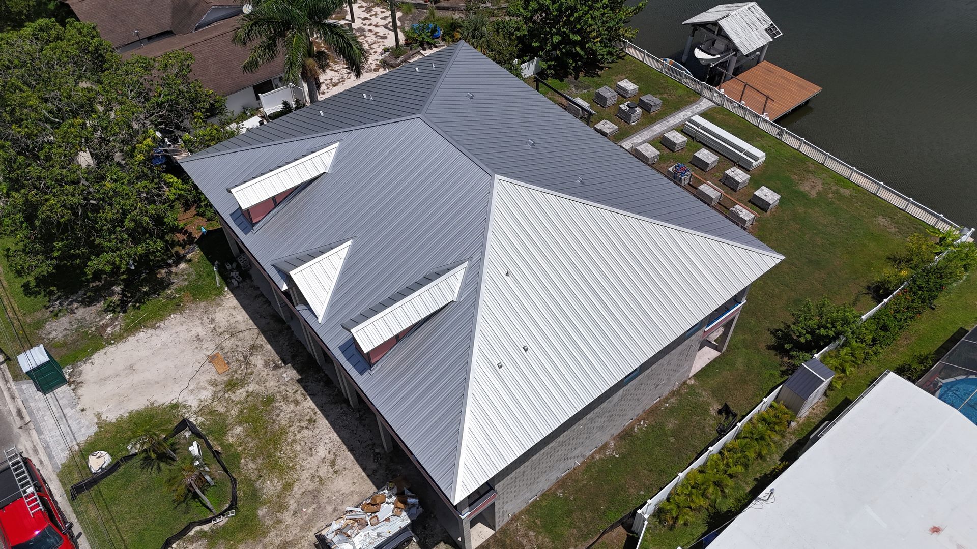 Roofer near you: Red Truck Roofing owner Gunner Heard on a customer's roof with the red truck below
