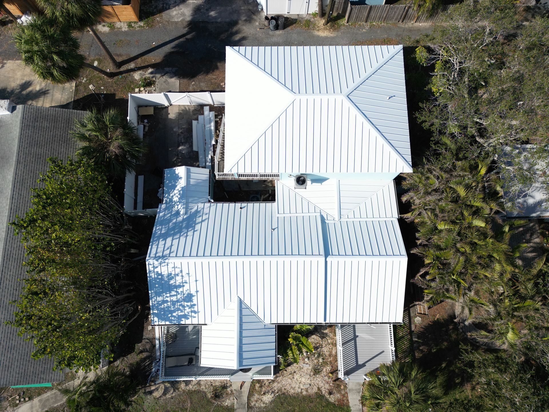 Metal roof installation near you: Red Truck Roofing crew rolling high temperature self adhered underlayment over a renailed deck before standing seam panels go on