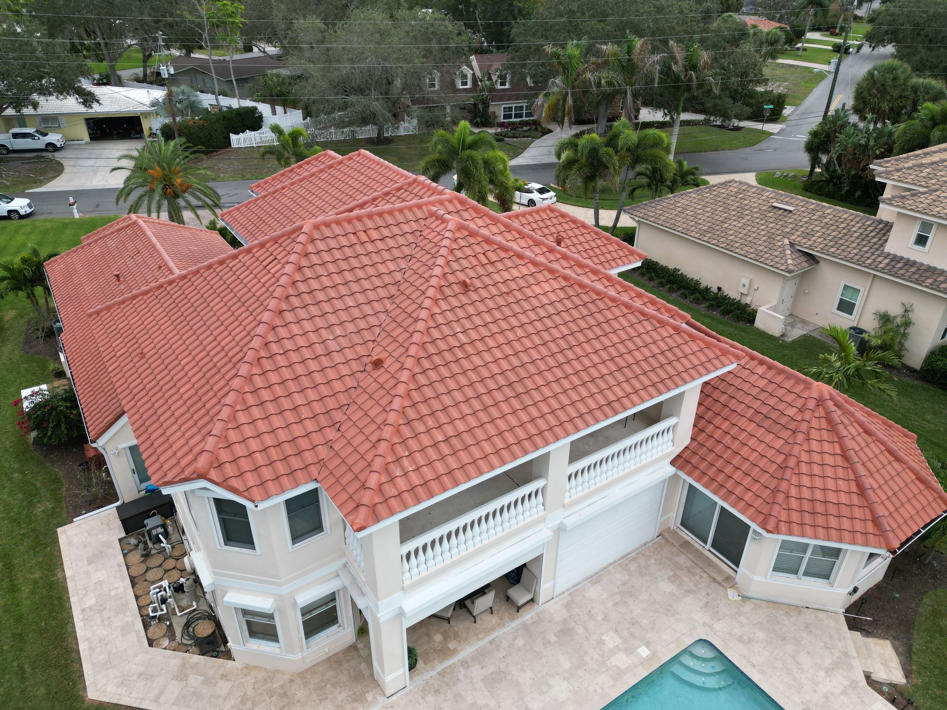 Tile roofing contractor near you: Red Truck Roofing work truck with Florida roofing license CCC1332514 and 813-RED-TRCK on the door in front of a new tile roof
