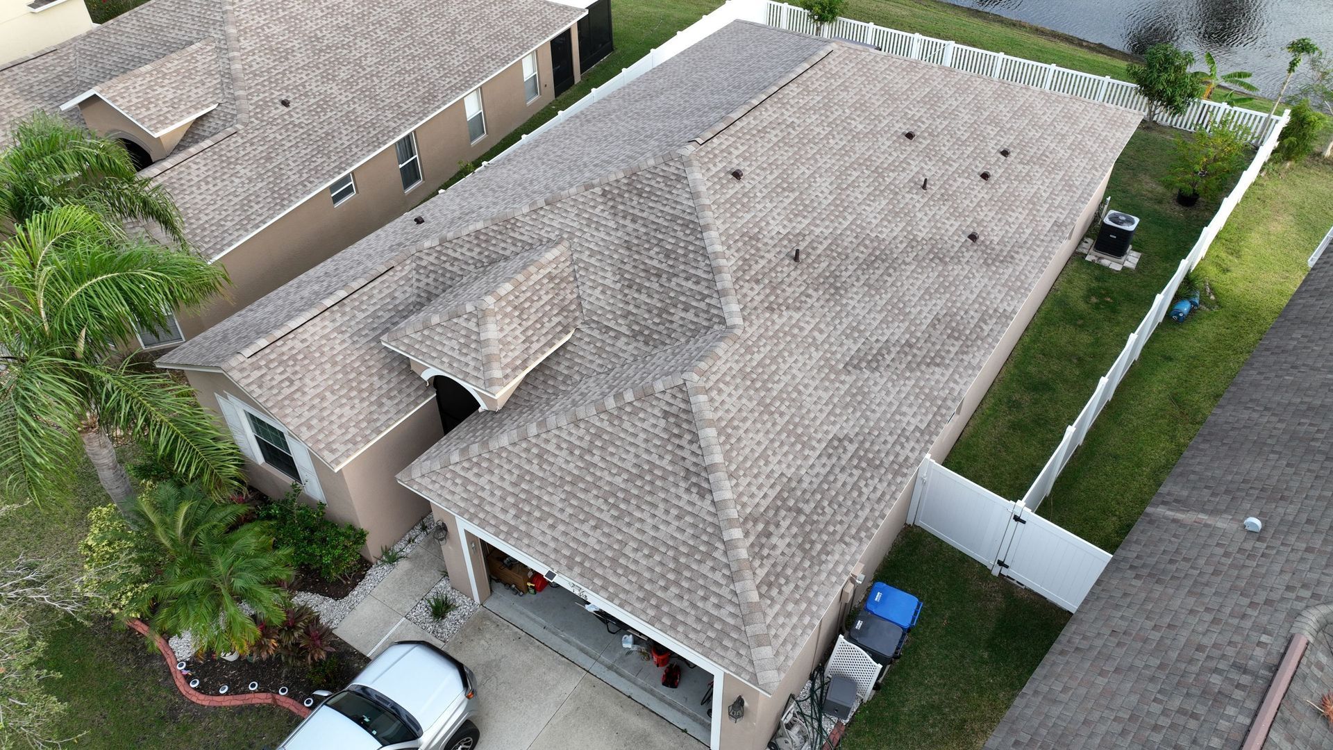 Roofer Tampa FL running a magnetic nail sweep across the lawn after a one day Red Truck Roofing roof replacement