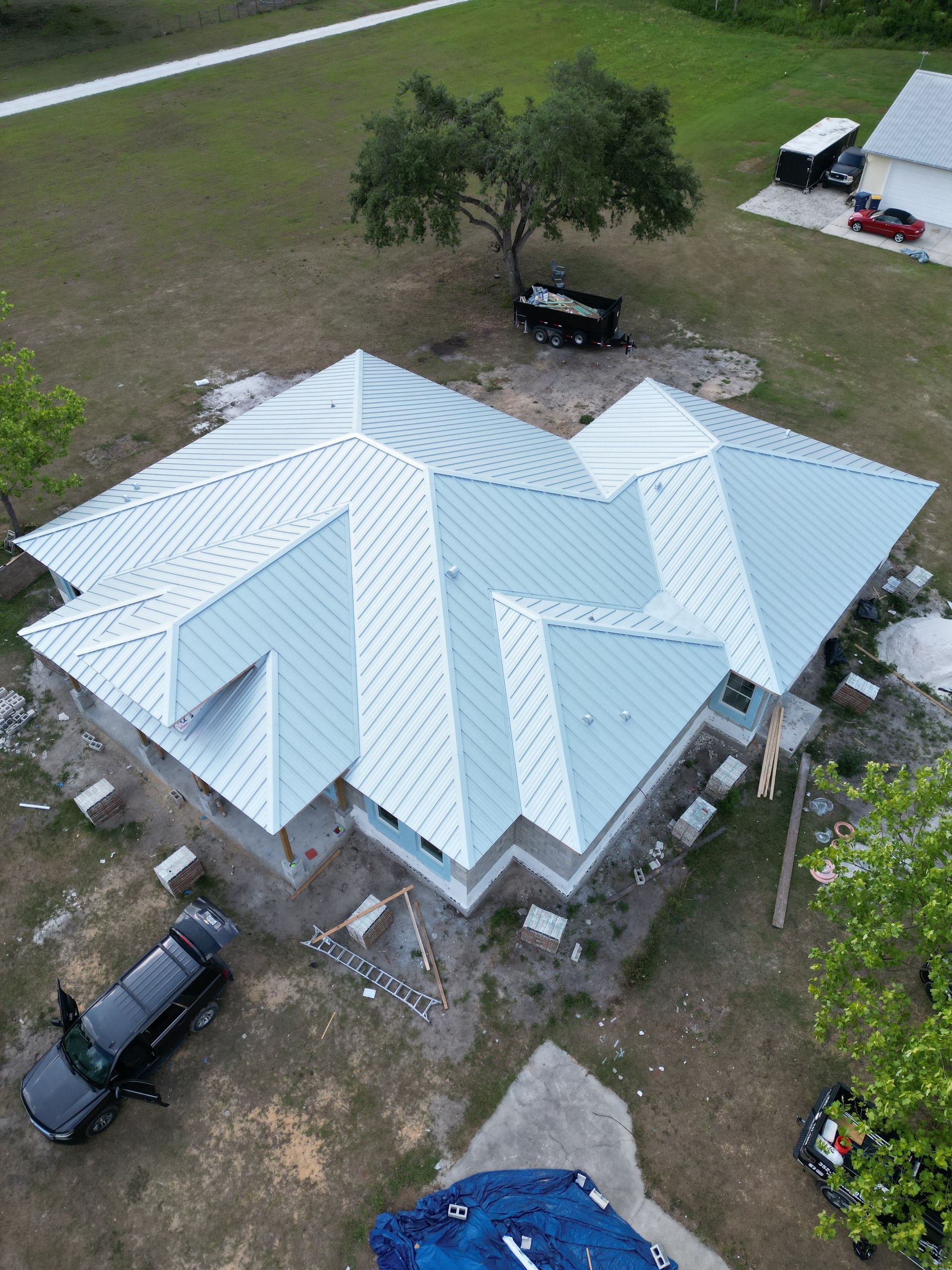 Standing seam metal roofing near you: Red Truck Roofing installer fastening a concealed clip on a Kynar finished standing seam panel