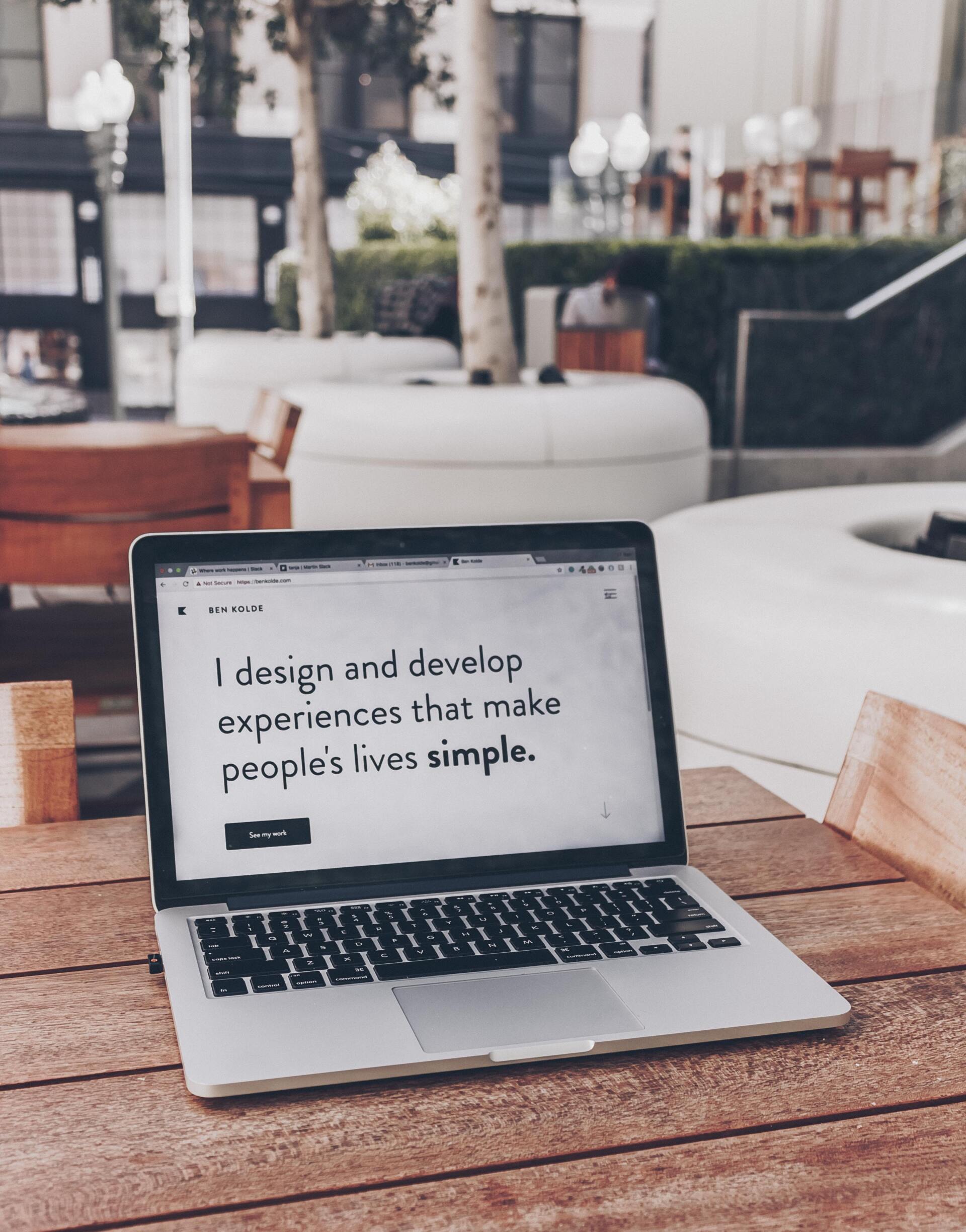 A laptop is open to a page that says i design and develop experiences that make people 's lives simple
