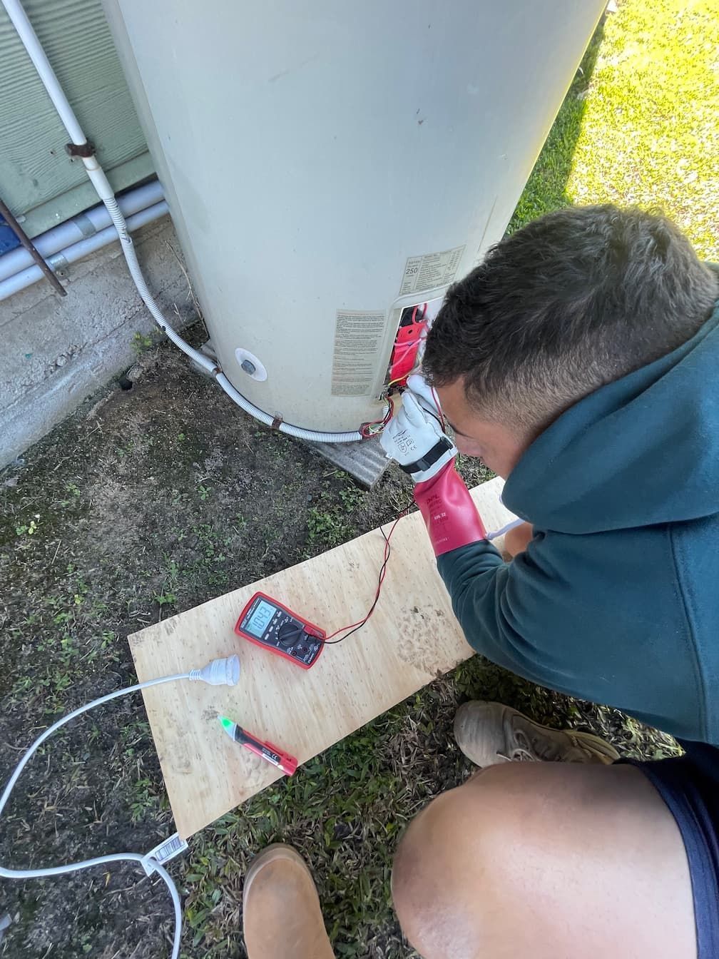 A person repairing a hot water system on the Sunshine Coast