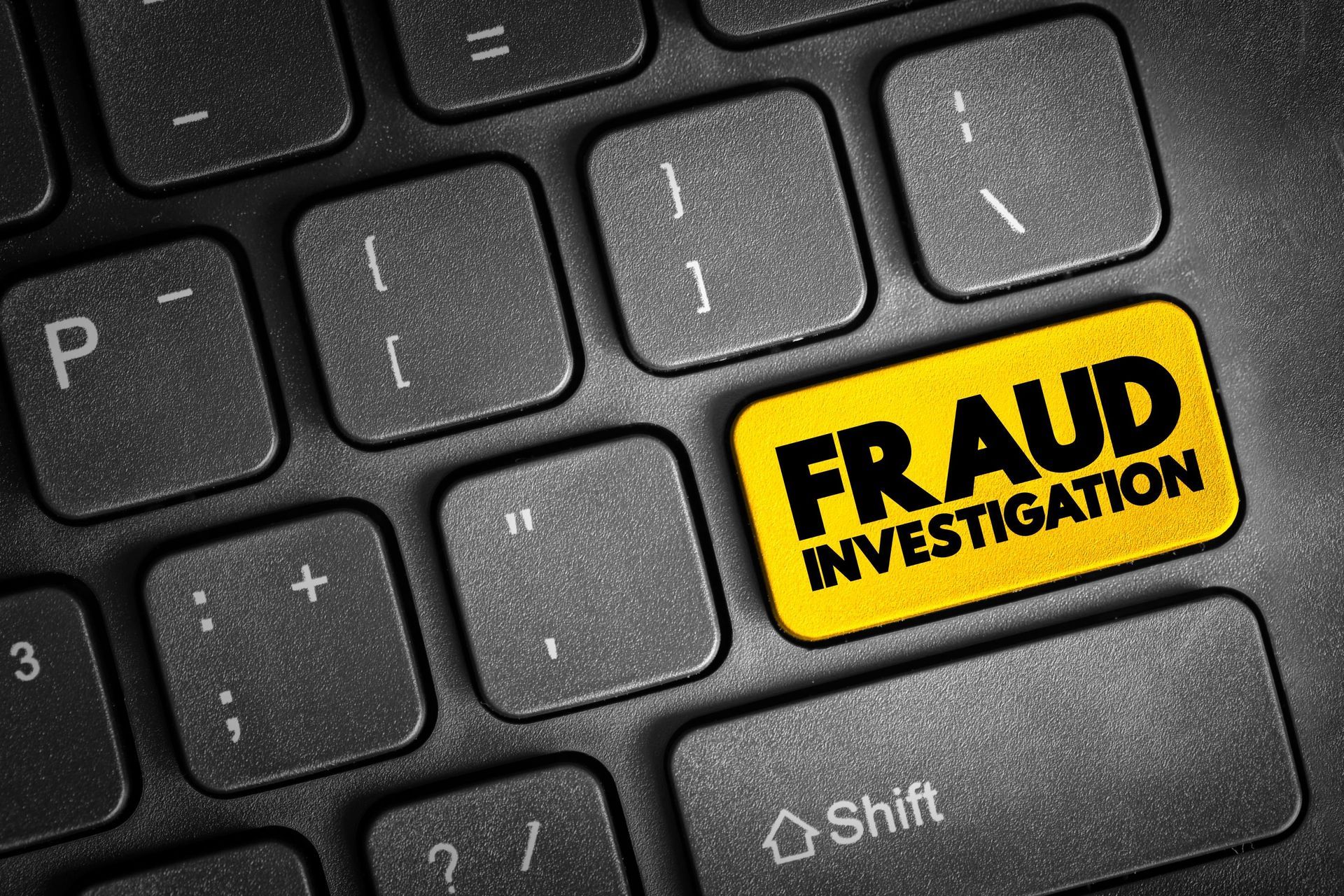 a black keyboard with a yellow button that says fraud investigation