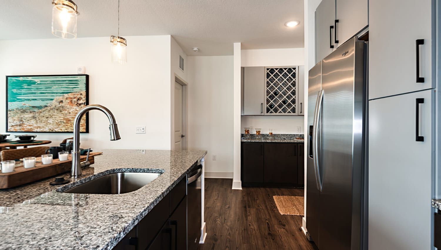 Modern kitchen with granite countertops, an island sink, and stainless-steel appliances.