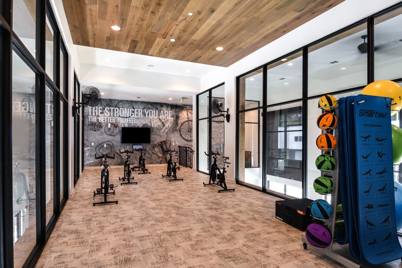 Indoor fitness center featuring stationary bikes, mats, and a wall mural.