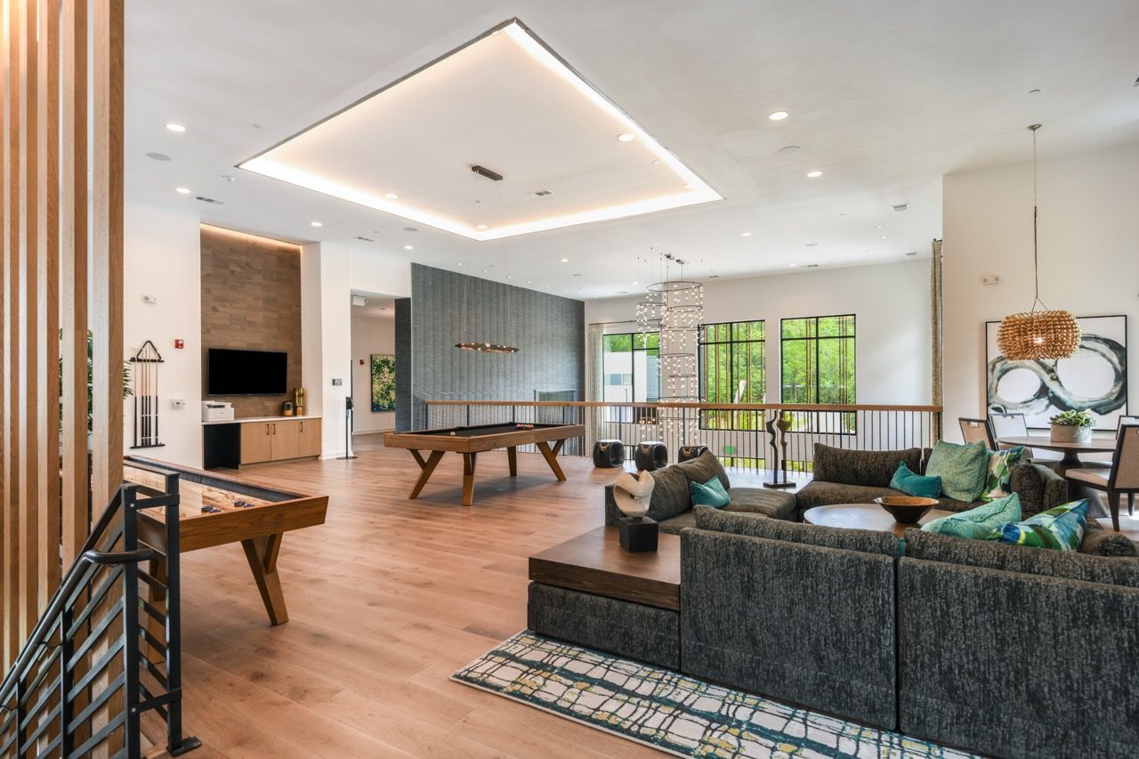 Spacious modern community lounge with sectional sofa, pool table, and large windows at Olympus Preserve at Town Center.