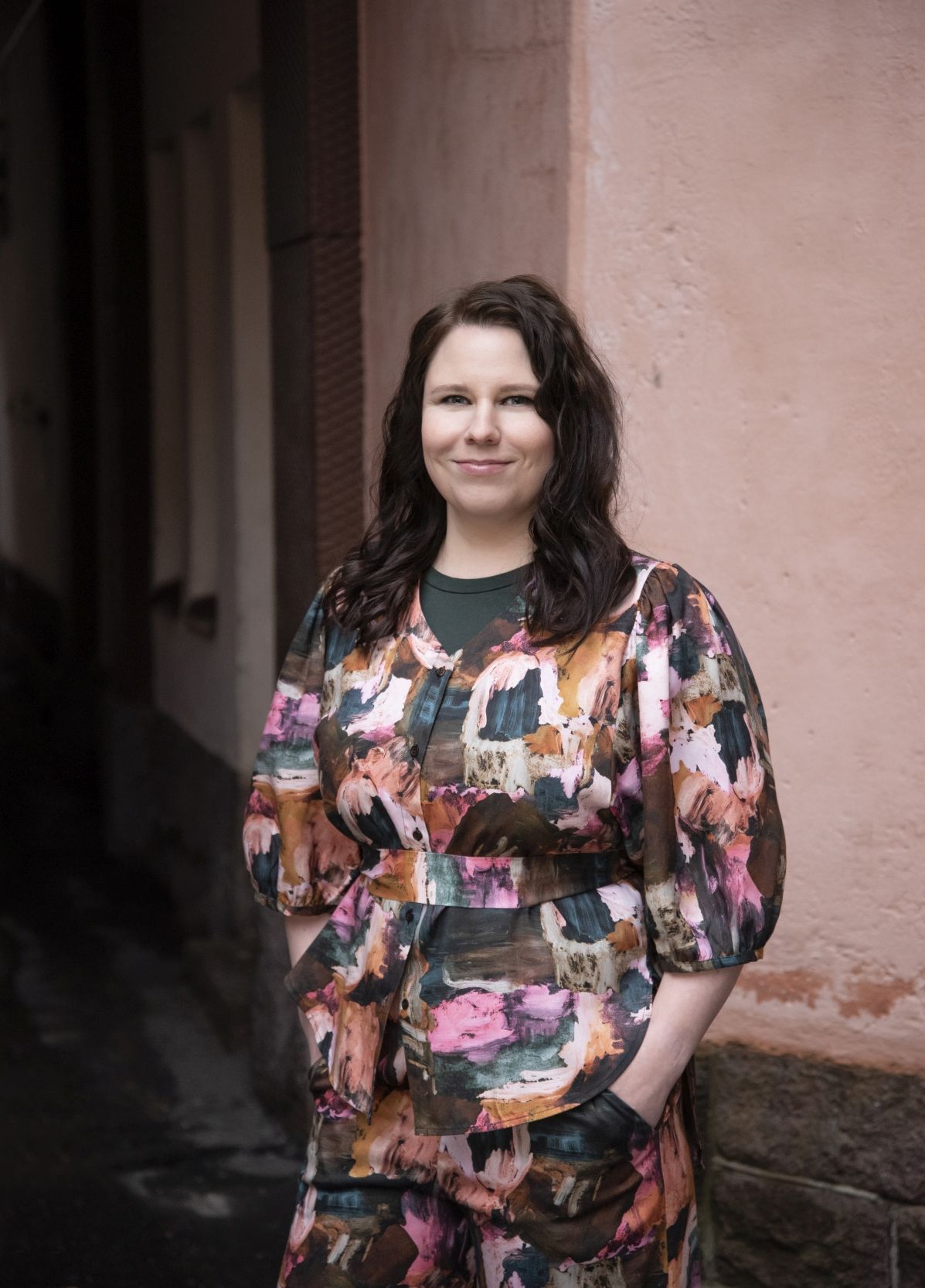 Kirjailija Helena Immonen katsoo kameraan ja seisoo kuvassa.
