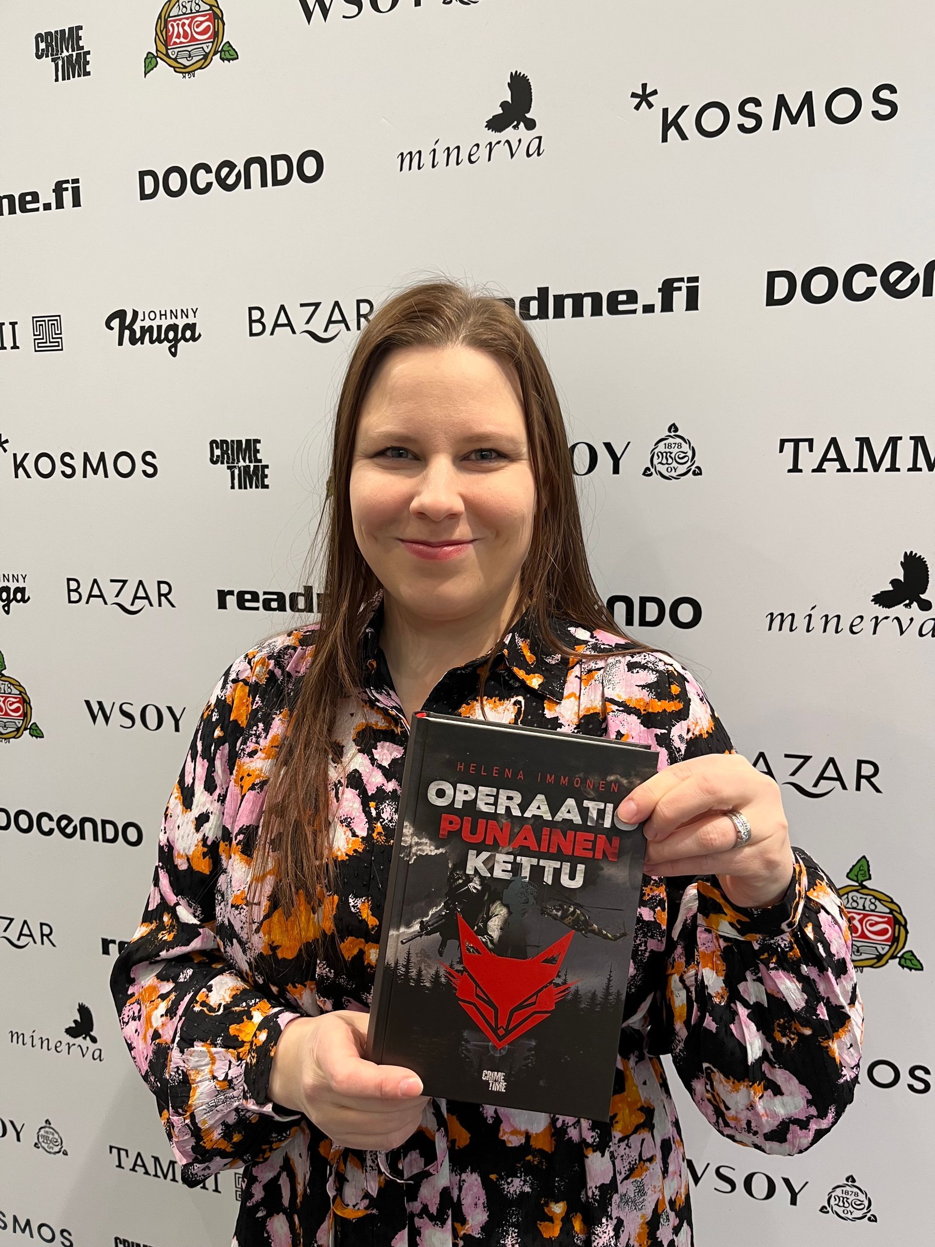 Kirjailija Helena Immonen poseeraa Operaatio Punainen kettu -kirjan kanssa