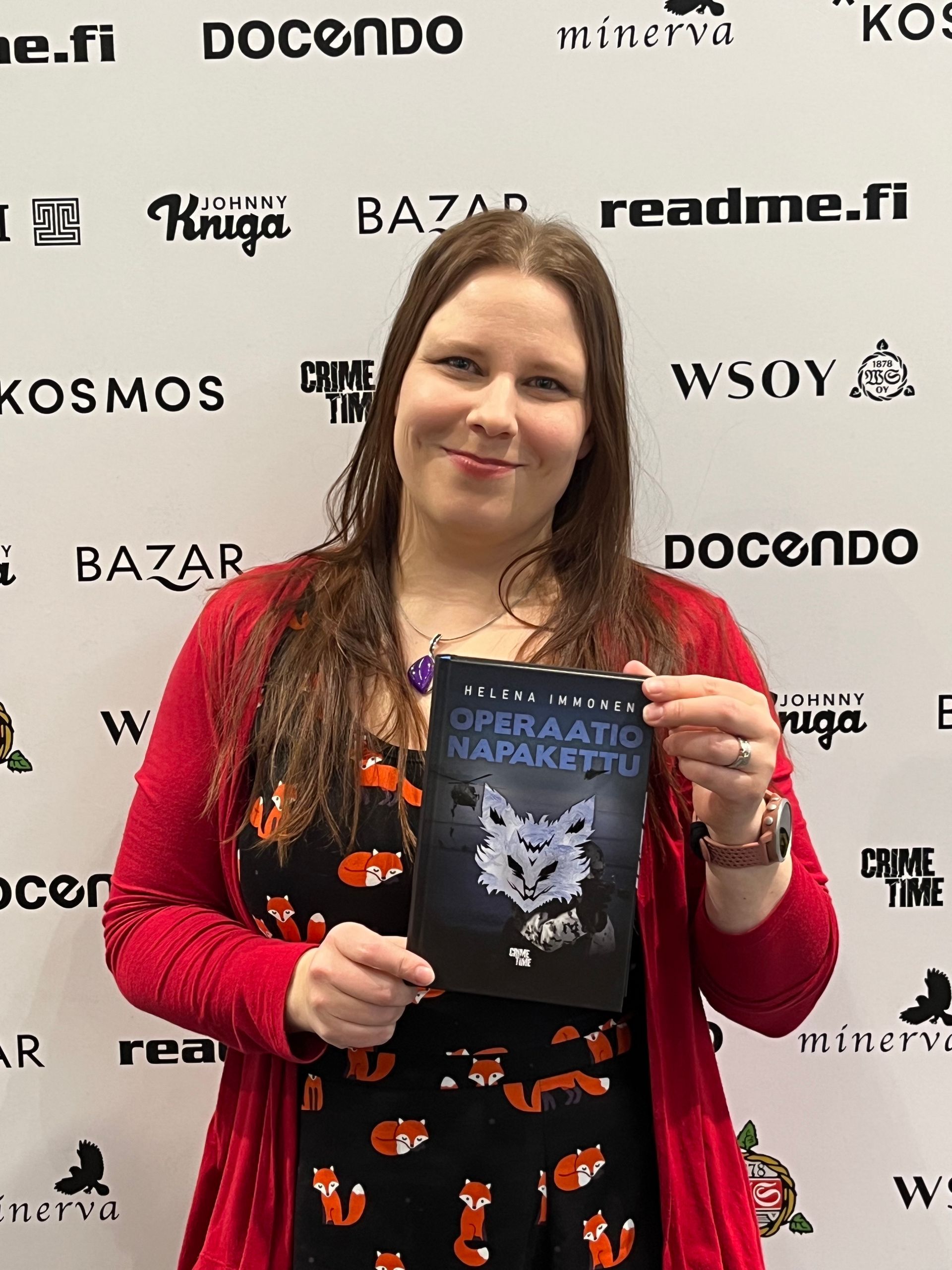 Kirjailija Helena Immonen poseeraa Operaatio Napakettu -kirjan kanssa