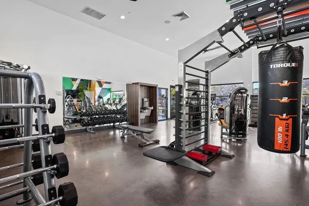 Modern gym with weights, cardio machines, and a punching bag at The Landing at Fiesta Village in mesa, AZ.