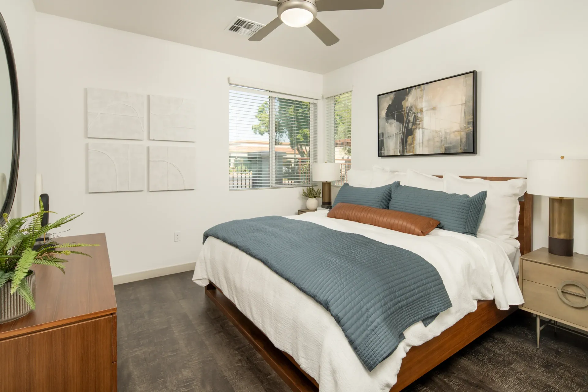 Bedroom with a queen-size bed, nightstand, dresser, and ceiling fan at The Landing at Fiesta Village in mesa, AZ.