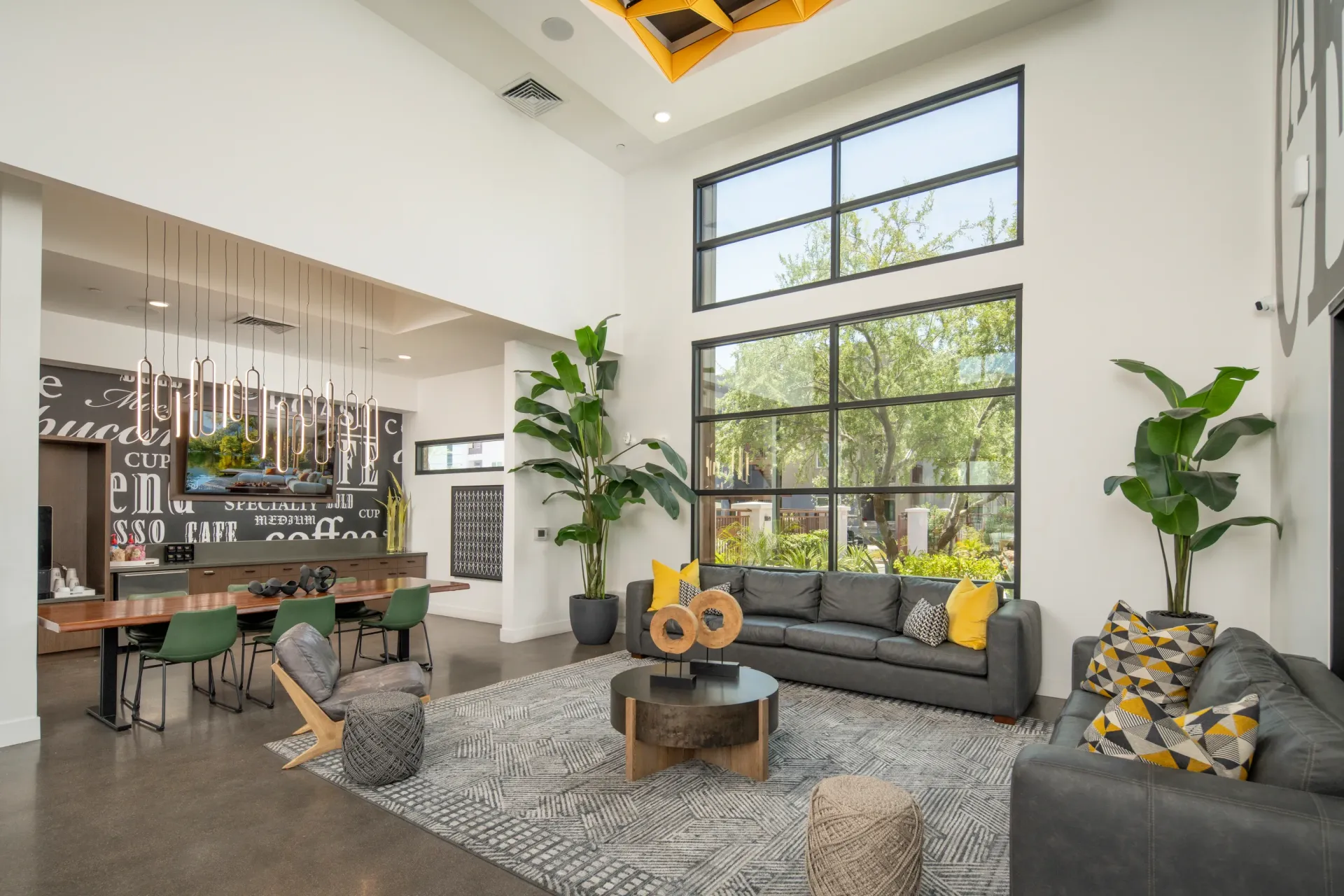 Modern lounge area with large windows, comfortable seating, and a coffee bar.