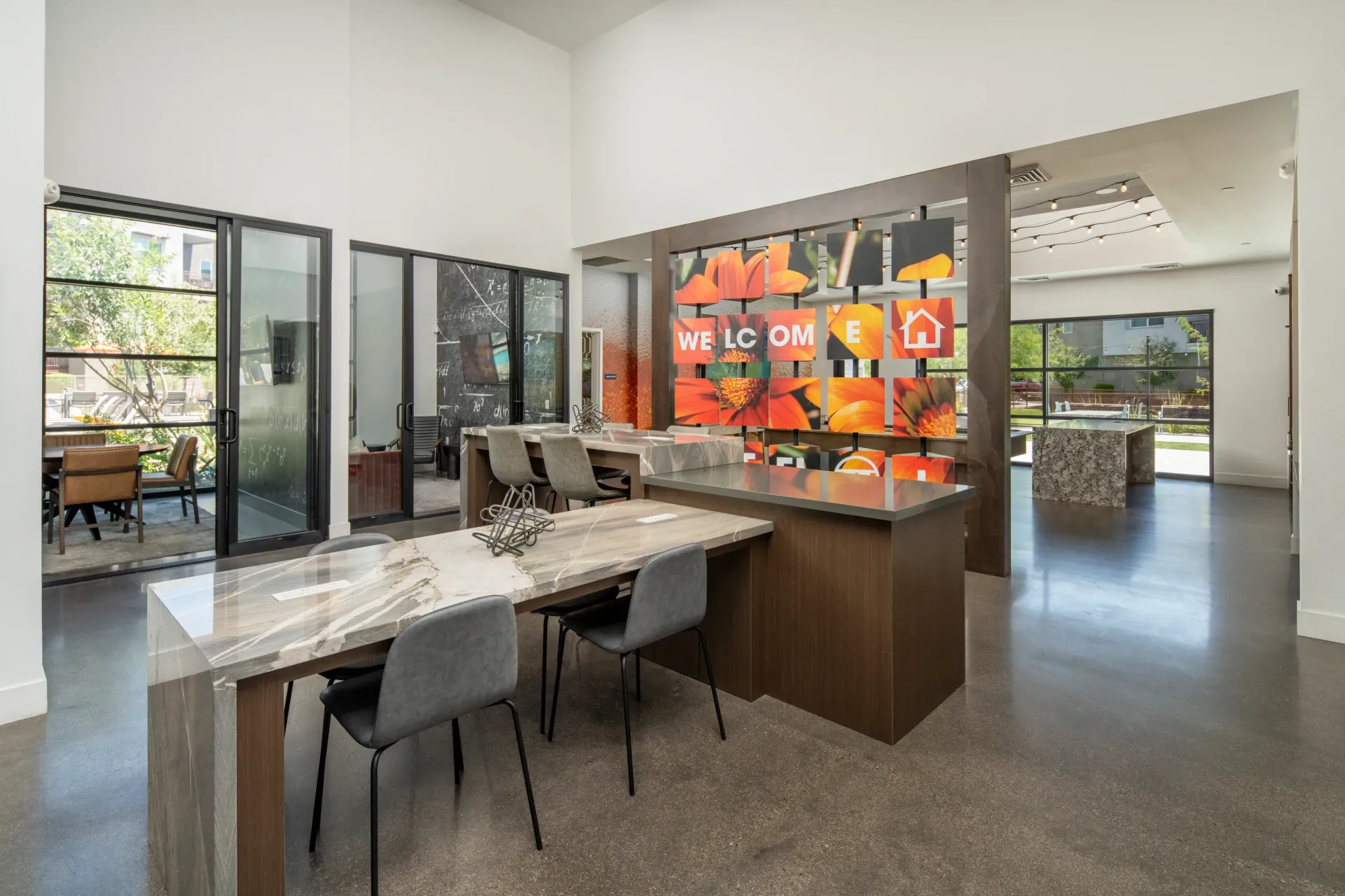 Modern leasing office with a welcome display, communal seating areas, and views of the outdoors at The Landing at Fiesta Village in mesa, AZ.