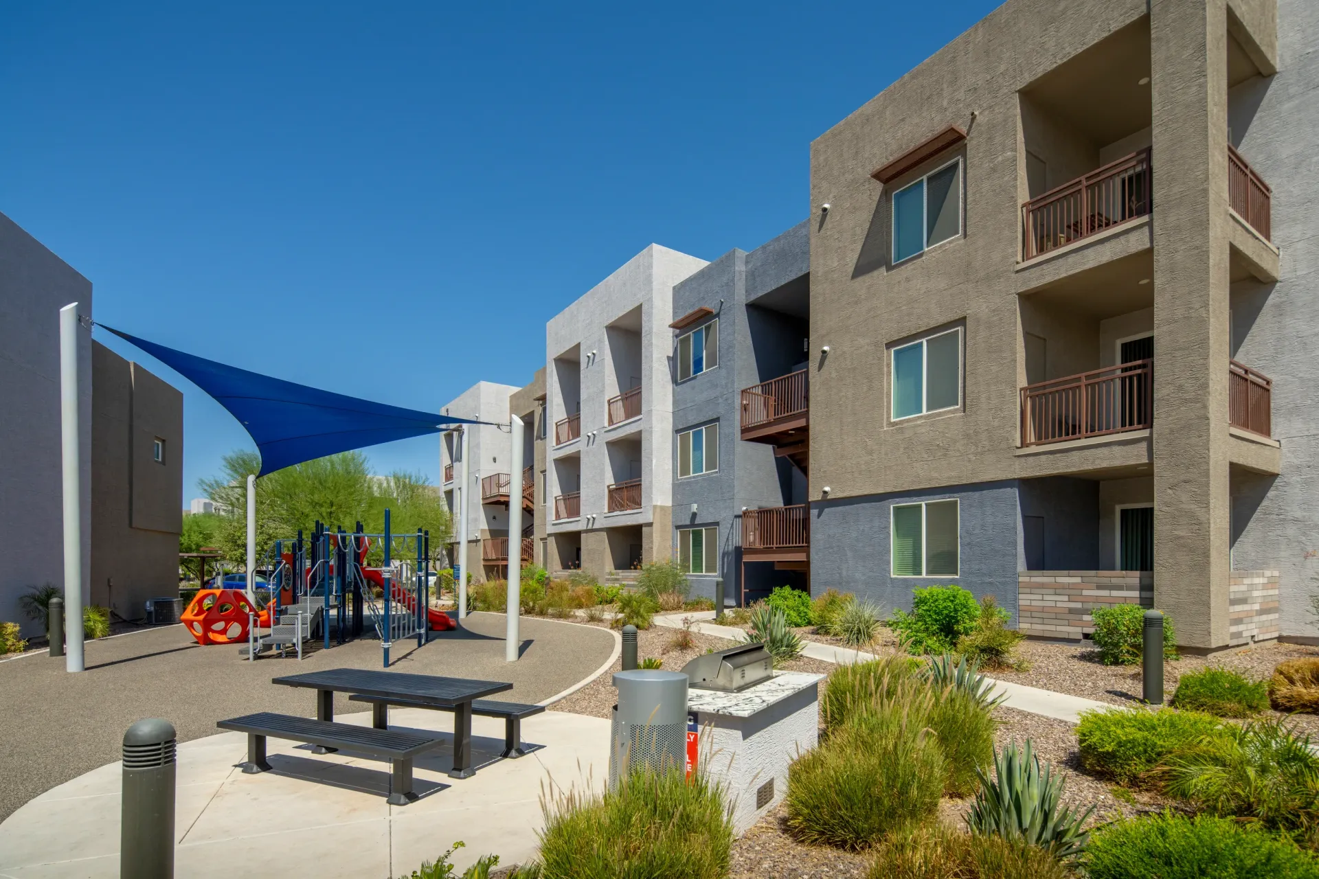 Children's playground and outdoor picnic area with grills at The Landing at Fiesta Village in mesa, AZ.