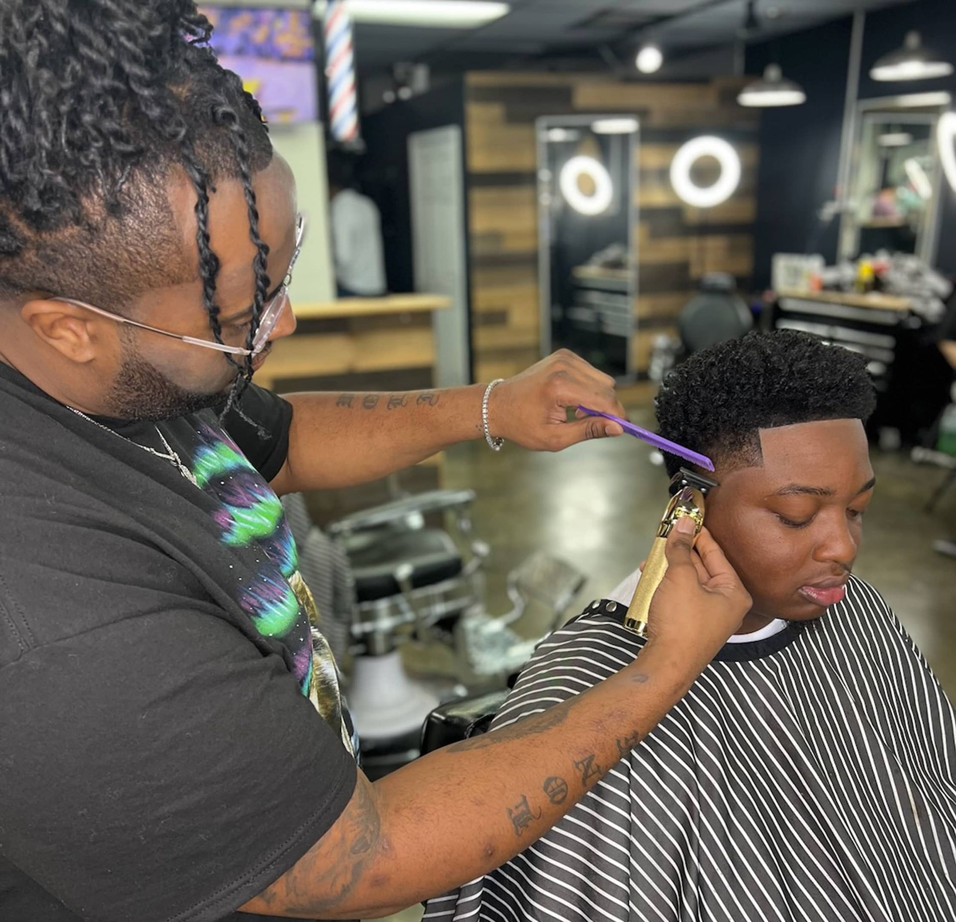 A man is getting his hair cut at a barber shop