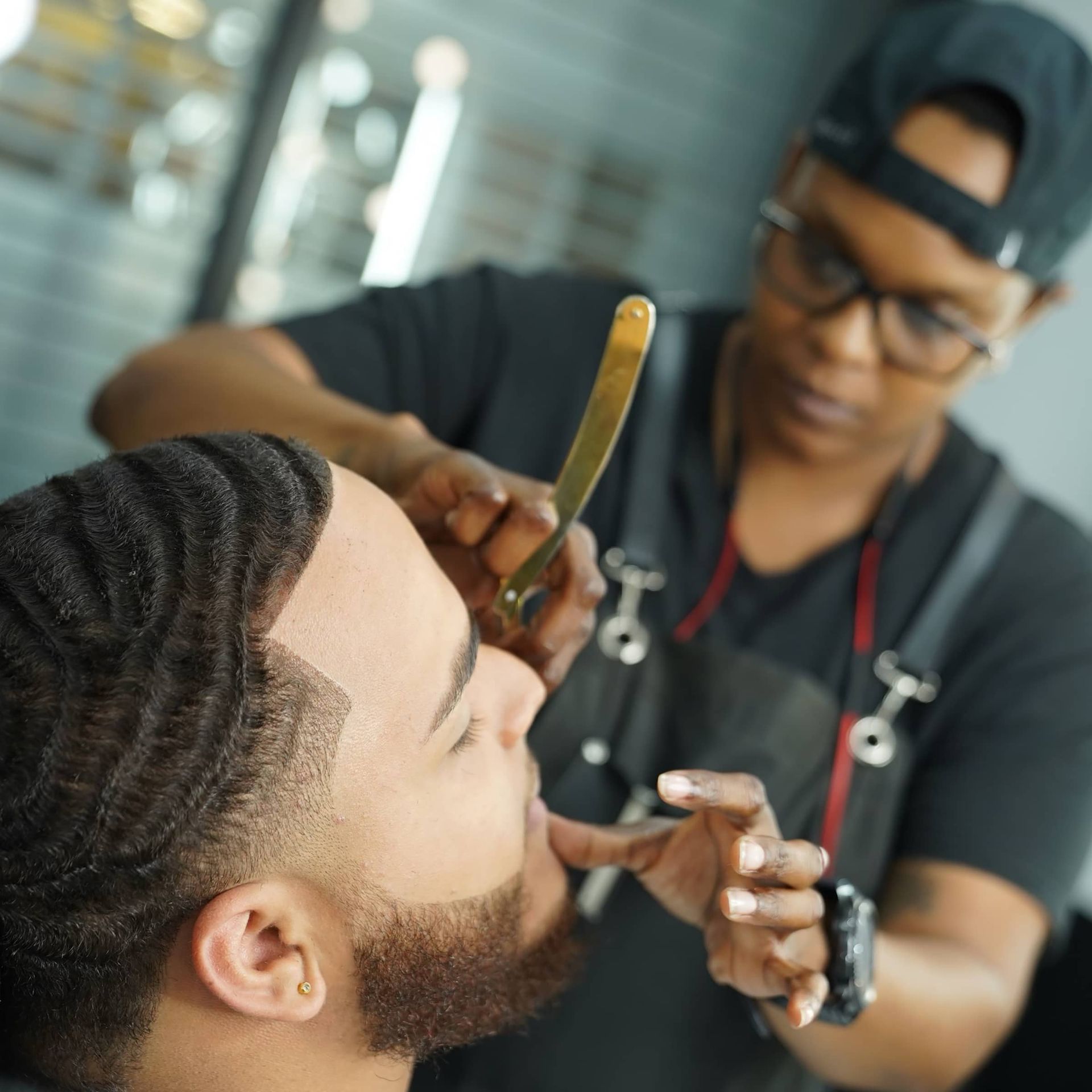 A man is getting his hair cut by a barber