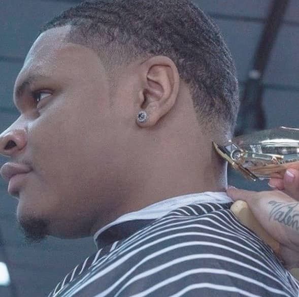 A man is getting his hair cut by a barber.