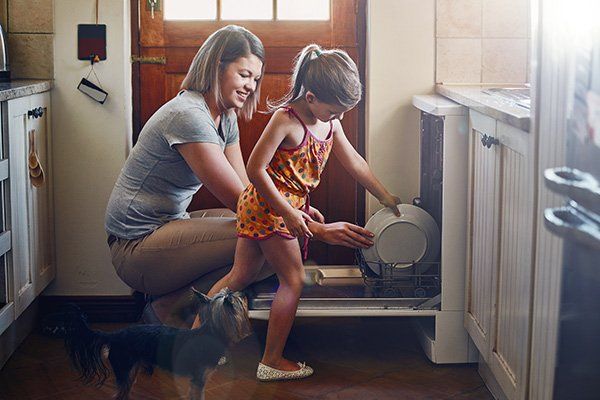 mother and daughter loading dishwasher