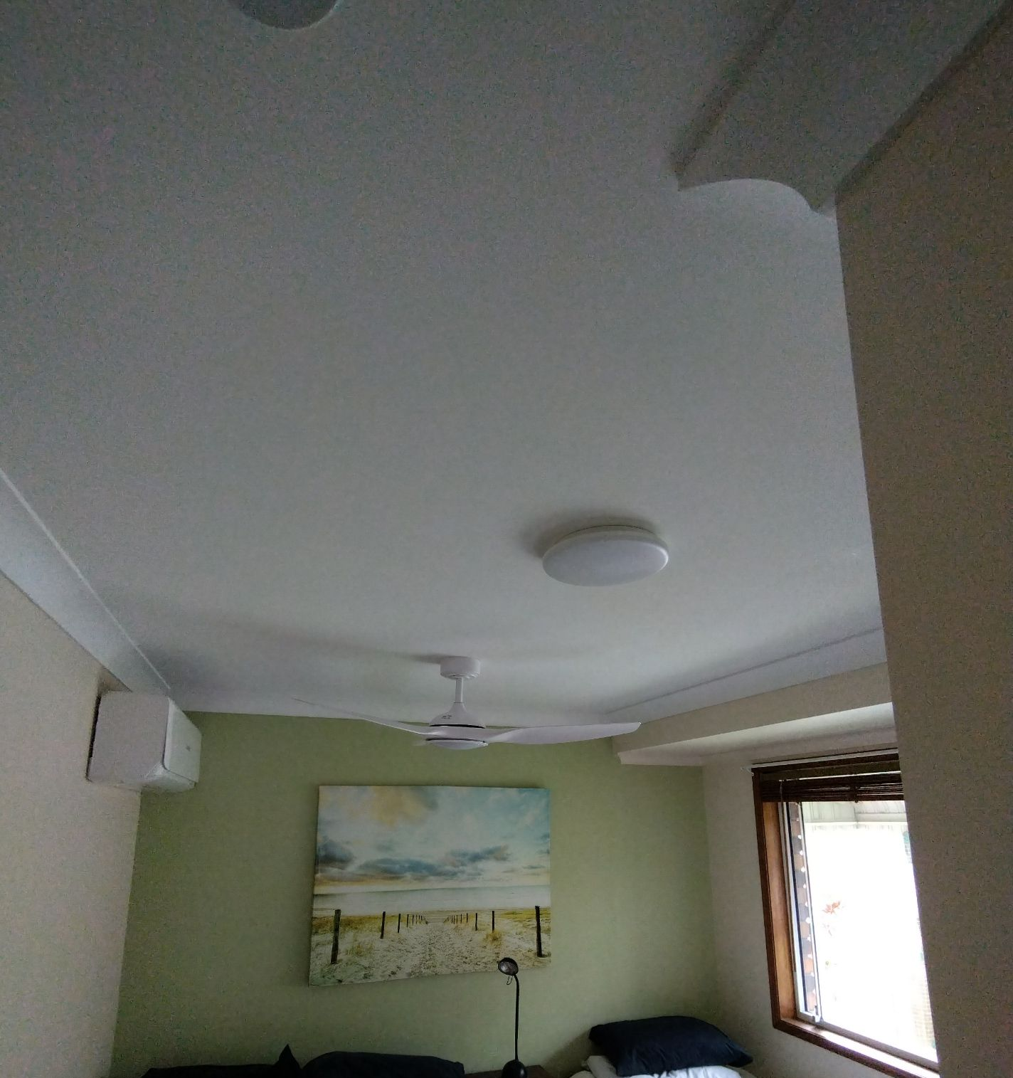 Two Twin Beds in a Room With a Painting, Fan, and Window — NTR Electrical In Maryborough, QLD