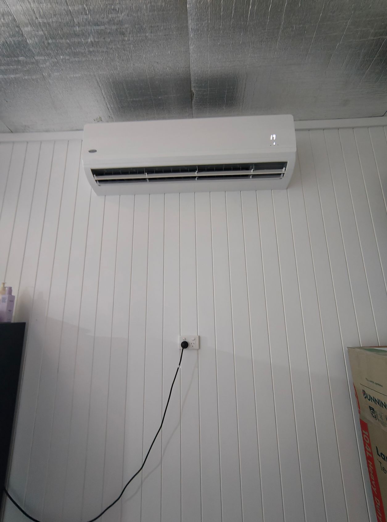 Person Removing Air Filter From a Wall-mounted Air Conditioning Unit — NTR Electrical In Toogoom, QLD