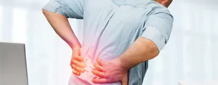 Person holding lower back with glowing red pain highlight, suggesting back pain or injury