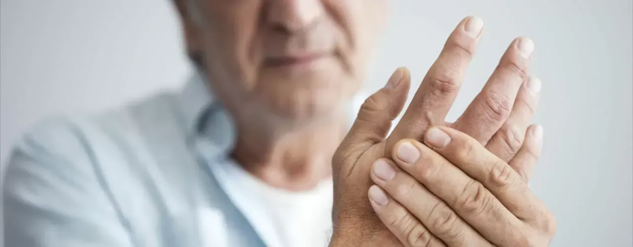 Close-up of hands with one hand rubbing the other, suggesting joint pain or arthritis